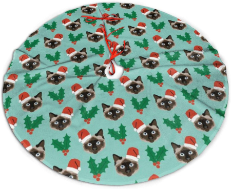 Christmas tree skirt decorated with holly and Siamese cat wearing Santa hat
