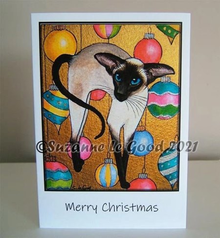 Seal Point Siamese cat with brightly colored Christmas decorations
