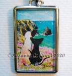 Siamese cat and Oriental friend gaze out over rocky cliffs and a blue bay in Cornwall, England