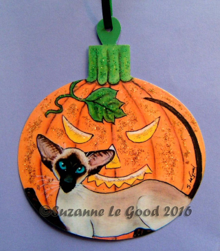 Hanging Halloween ornament featuring orange pumpkin and Siamese cat, by Suzanne Le Good