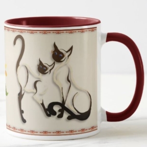 Stylized Siamese cats eyeing a yellow daisy flower, design on a coffee mug
